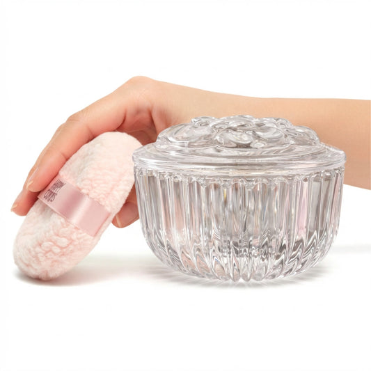 Happy Curves Comfort Puff resting against the crystal-clear glass vanity jar